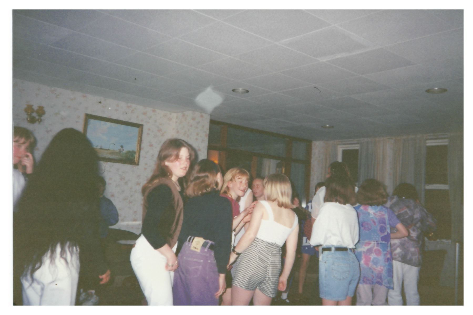 A group of young people dancing at a party in a hotel lounge