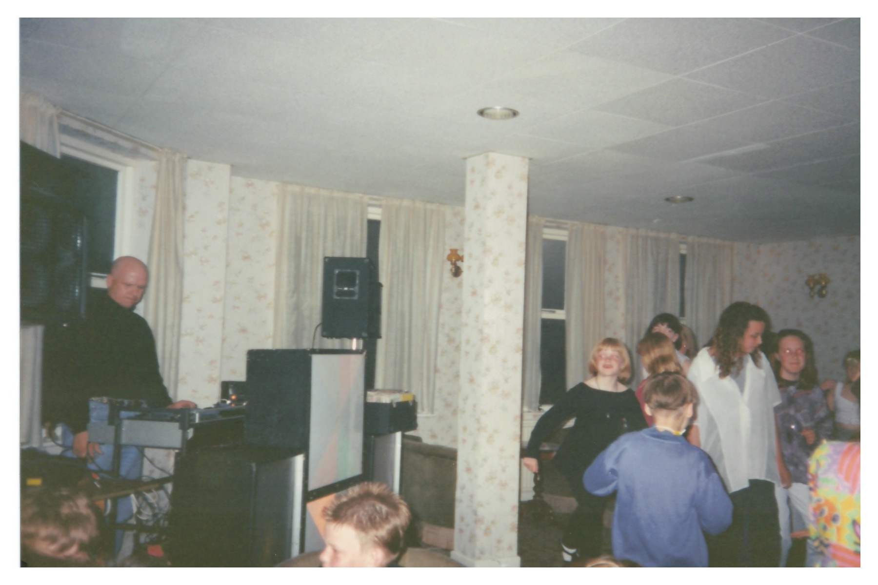 A group of young people dancing at a party in a hotel lounge